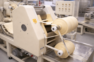 Máquina industrial da Keishi produzindo massa fresca com controle de processo e rastreabilidade na fábrica.