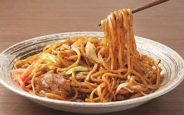 Macarrão de yakissoba salteado com legumes coloridos e proteínas, envolto em molho brilhante, destacando textura e qualidade da linha profissional de yakissoba da Keishi.